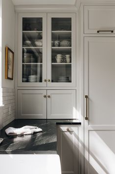 a kitchen with white cabinets and black counter tops