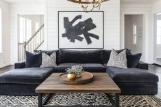 a living room filled with furniture and a chandelier hanging over the coffee table