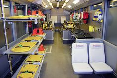 the inside of a train with several seats and yellow safety vests on each seat