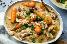 a white bowl filled with chicken and vegetable soup