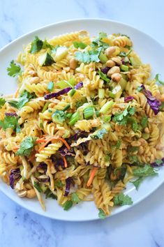 a white plate topped with pasta and veggies