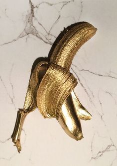 a gold banana on top of a marble counter next to an instagram sticker