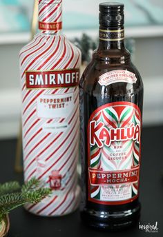 two bottles of kahlua coffee sit on a table next to a candy cane