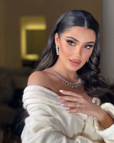 an image of a woman with long hair and jewelry on her chest posing for the camera