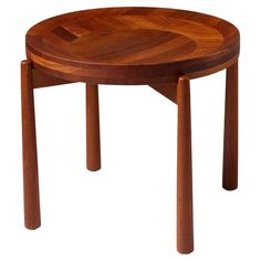 a wooden table with two legs and a circular design on the top, against a white background