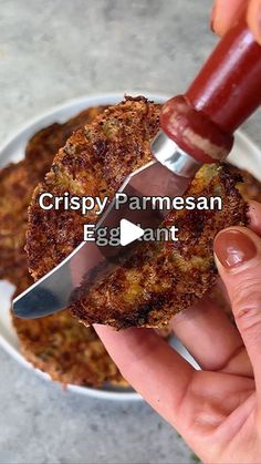 a person holding a knife in their hand with food on the plate behind it and text that reads crispy parmesan egg ant