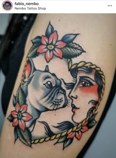 a woman's tattoo with two dogs on her thigh and flowers in the background