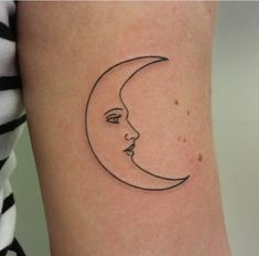 a woman's arm with a crescent moon tattoo on the left side of her body