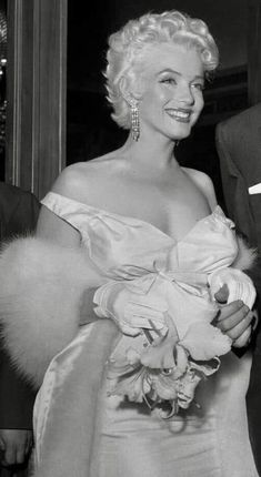 an old black and white photo of a woman in a dress with fur stoler