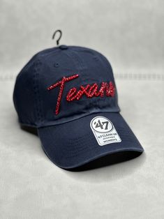 This is a navy blue HOU Texans script 47 clean up adjustable hat that is hand embellished with varying sizes of transparent red Swarovski crystals on the front text. This hat features over 150+ varying size Swarovski crystals. - 100% Cotton - Matching fabric strap & buckle - One Size Fits All - Raised Embroidered Logo - 150+ Swarovski transparent red crystals individually placed by hand - Ready to ship in 1 week from San Diego, CA Rhinestone Football, Bling Hat, Texans Logo, Sports Hat, Fabric Strap, Sport Hat, Womens Football, Houston Texans, Svg Designs