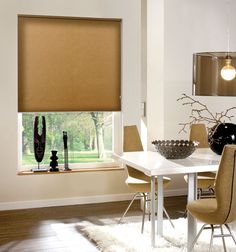 a white table and chairs in a room with brown shades on the window sill