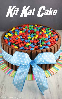 a cake with chocolate frosting and colorful candy toppings on top that says kitkat cake