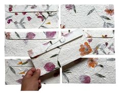 several pieces of paper with flowers on them being cut into small squares and placed in front of each other