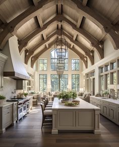 a large open kitchen and dining room with wood beams on the ceiling, along with an island