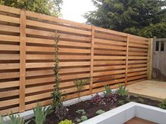 a wooden fence in the middle of a garden