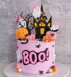 a halloween cake with pink frosting and spooky decorations