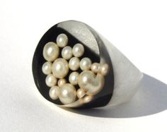 a close up of a ring with pearls on it