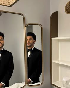 a man in a tuxedo looking at himself in the mirror