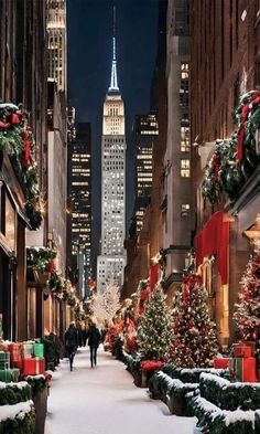 people walking down a snowy street with christmas decorations on the sidewalks and buildings in the background