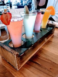 four different types of drinks on a tray