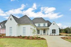 a large white house sitting on top of a lush green field