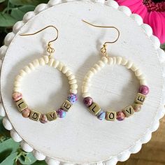 Gorgeous boho hoop earrings with the word LOVE are looped with neutral colored beads and multi colored beads then hung from gold plated ear wires.  Please look at all pictures and read full description.  Ear wires are gold plated and nickel free. I love using other Etsy shops for my supplies when possible. It not only supports other small businesses but gives your purchase an extra touch of uniqueness ❤️ Please look at all photos and the video for additional details. Width measurements are made at the widest point.  Earrings are ready to ship. They will ship within 3 business days. Please keep in mind postal holidays as that may delay shipping by a day or two.  Your earrings will be shipped safely in a jewelry box. For earrings that are too large for the box, they will be wrapped in tissue Bohemian Heishi Beads Hoop Earrings As Gift, Boho Hoop Earrings, Resin Projects, Colorful Jewelry, Circle Earrings, Earrings For Women, Handmade Earrings, Ear Wires, Boho Jewelry