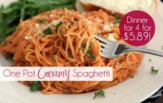 a white plate topped with spaghetti next to bread and veggies on a table