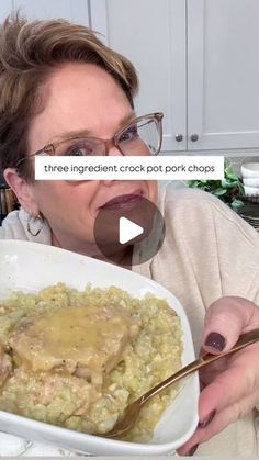 a woman holding a spoon in front of a bowl of food with meat and gravy