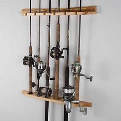 there are many fishing rods and reels hanging on the wall