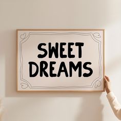 a person holding up a sign with the words sweet dreams written in black on it