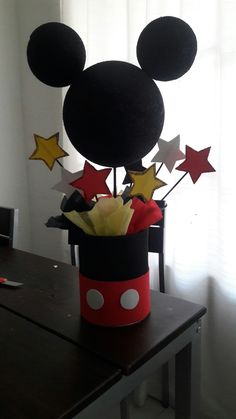 a mickey mouse hat with stars in it on top of a table next to a window