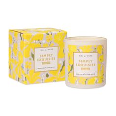 a candle in a yellow box next to it's packaging on a white background