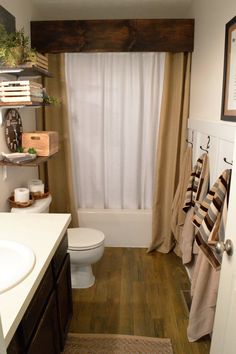 a bathroom with a toilet, sink and shower curtain in it's window sill