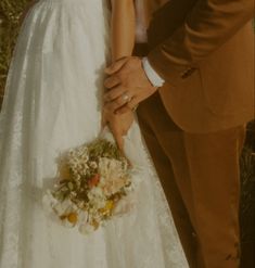 the bride and groom are holding each other's hand as they stand close together