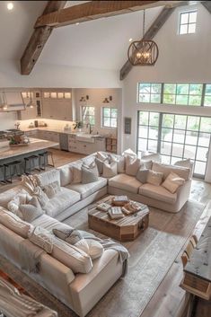 a living room filled with lots of furniture next to a kitchen and dining room table