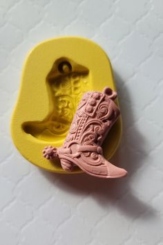 a rubber stamp shaped like a boot with a shoe on it's side, sitting on a white surface