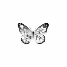 a black and white photo of a butterfly with flowers on it's back wing