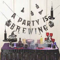 a purple table topped with lots of bottles and glasses next to a sign that says, a party is brewing