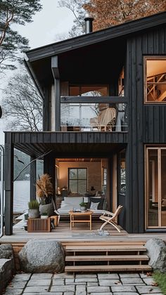 a house that is next to the water and has wooden steps leading up to it