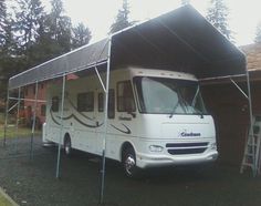 a white motor home parked in front of a garage