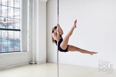 a woman in black leotard doing pole dancing