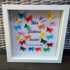 a white frame with colorful paper butterflies in it