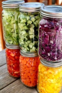 four mason jars filled with different types of vegetables