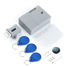 four keychains are shown in front of an electronic device