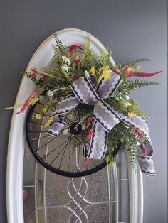 a wreath on the front door of a house decorated with flowers and ribbons for christmas