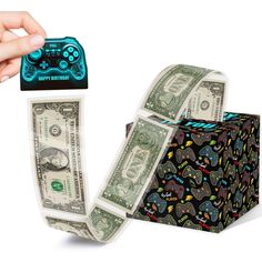 a hand holding a roll of money with a video game controller on top of it