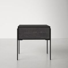 an end table with black legs and a drawer