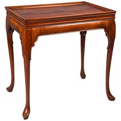 an antique wooden table with one drawer on the top and two legs at the bottom