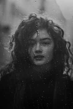 a woman standing in the rain with her eyes closed