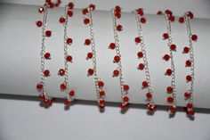 several red beads are on a silver chain